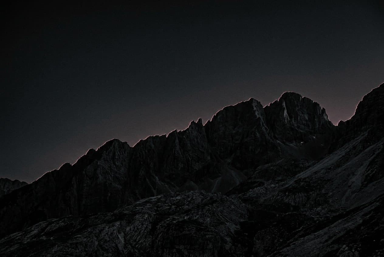 A dark mountain ridge with a faint rose rim light — the quiet, local boundary ZANCTA keeps around your files